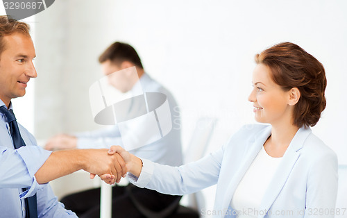 Image of man and woman shaking hands in office