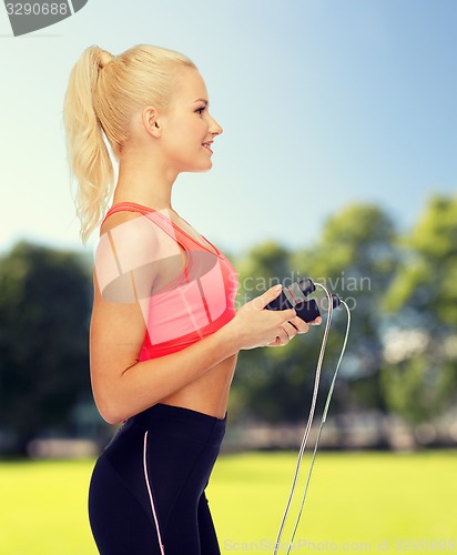 Image of smiling sporty woman with skipping rope