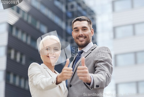 Image of smiling businessmen showing thumbs up