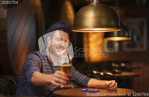 Image of happy man drinking beer at bar or pub