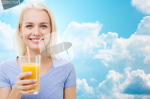 Image of smiling woman drinking orange juice