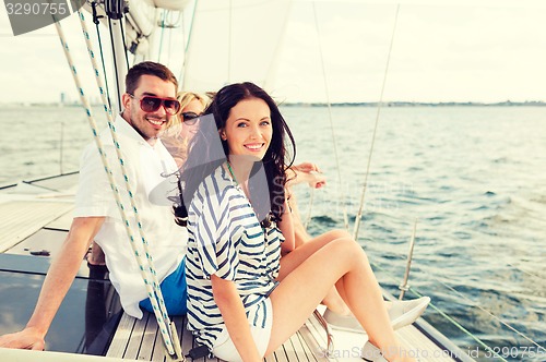 Image of smiling friends sitting on yacht deck