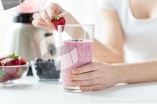 Image of close up of woman with milkshake and strawberry