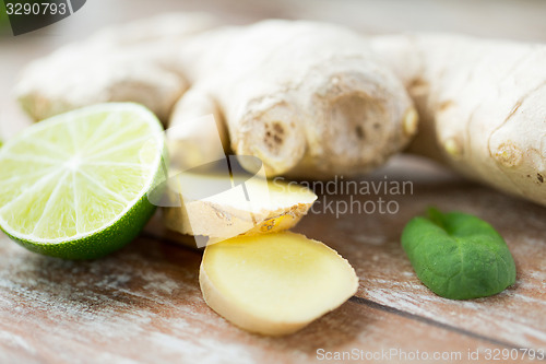 Image of close up of ginger root and lime on wooden table