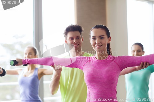 Image of group of smiling people working out with dumbbells