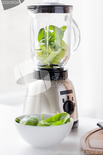 Image of close up of blender jar and green vegetables