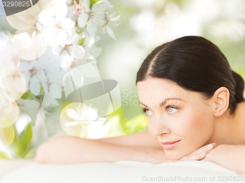 Image of happy beautiful woman lying in spa