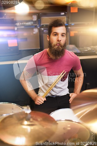Image of male musician playing cymbals at music store