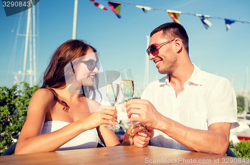 Image of smiling couple drinking champagne at cafe
