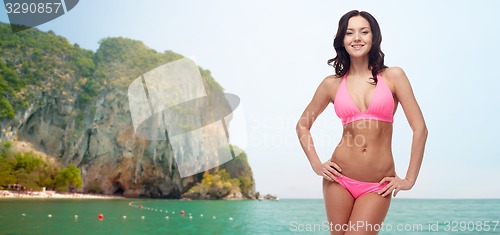 Image of happy young woman in pink bikini swimsuit