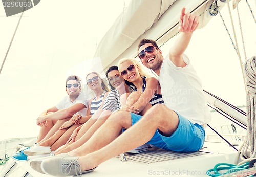 Image of smiling friends sitting on yacht deck