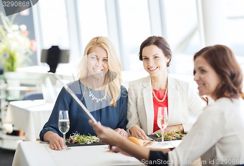 Image of women with smartphone taking selfie at restaurant