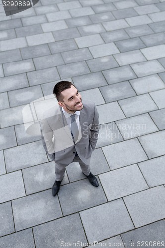 Image of young smiling businessman outdoors from top