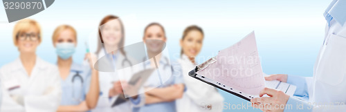 Image of female doctor holding clipboard with cardiogram