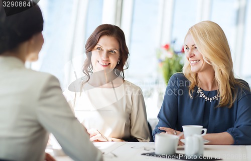 Image of women drinking coffee and talking at restaurant