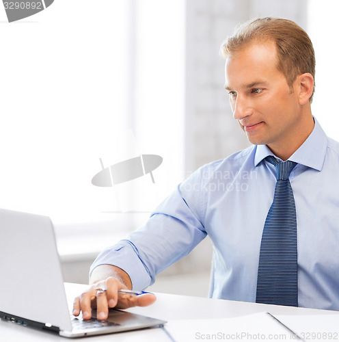 Image of miling businessman working in office