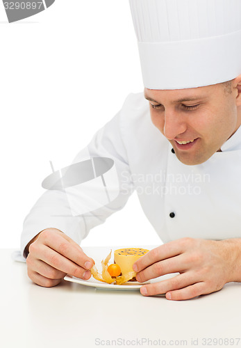 Image of close up of male chef cook decorating dessert