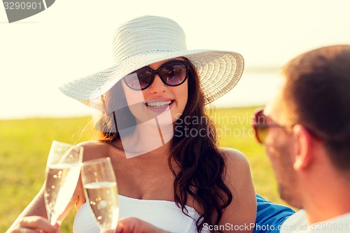 Image of smiling couple drinking champagne on picnic