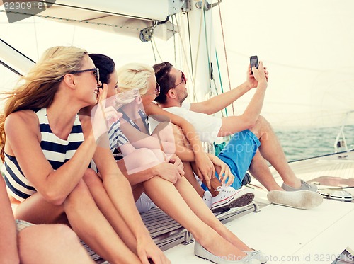 Image of smiling friends sitting on yacht deck