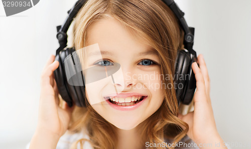 Image of little girl with headphones at home