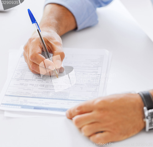 Image of man filling tax form