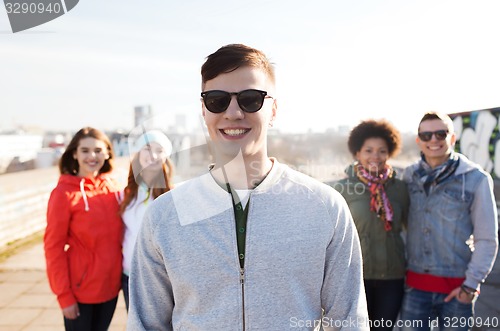 Image of group of happy teenage friends on city street