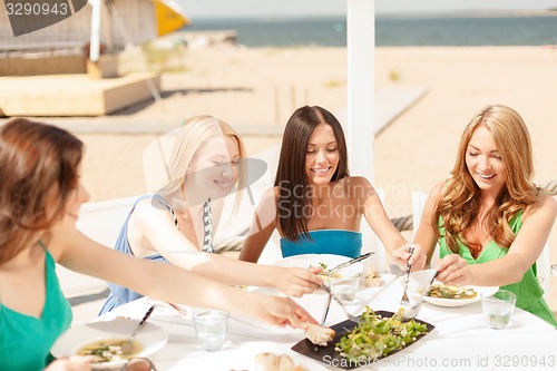 Image of smiling girls in cafe on the beach