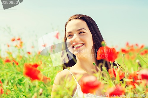 Image of smiling young woman on poppy field