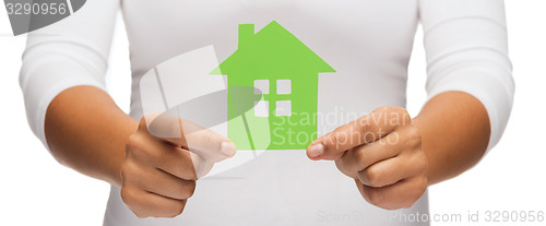 Image of woman hands holding green house