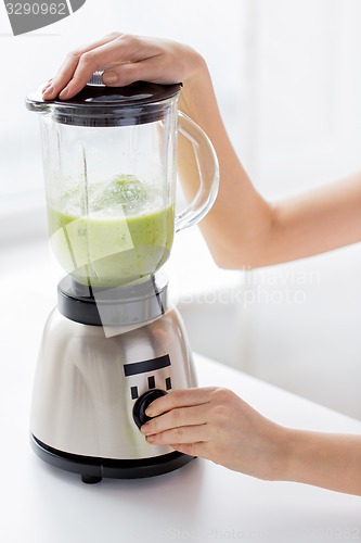 Image of close up of woman hands with blender making shake