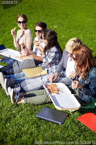 Image of group of teenage students eating pizza on grass