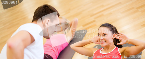 Image of group of smiling women doing sit ups in the gym