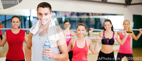 Image of smiling trainer in front of group of people