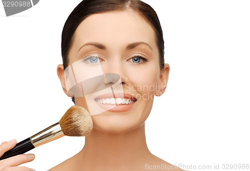 Image of woman applying powder foundation with brush