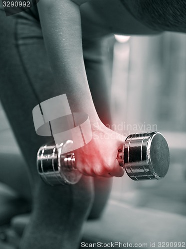 Image of close up of woman with dumbbell exercising in gym