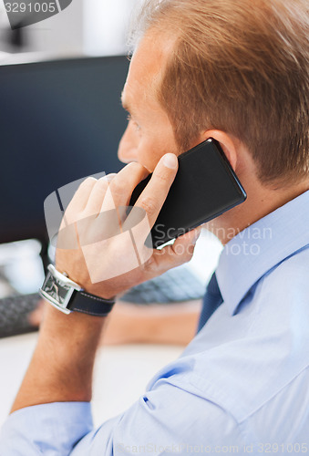 Image of businessman with smartphone in office