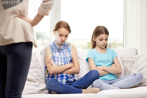 Image of upset guilty little girls sitting on sofa at home