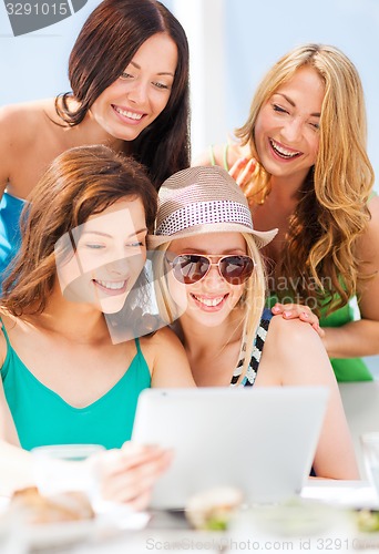 Image of girls looking at tablet pc in cafe