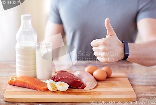 Image of man with food  rich in protein showing thumbs up