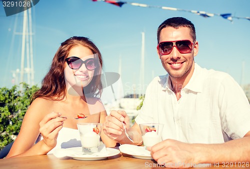 Image of smiling couple eating dessert at cafe