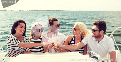 Image of smiling friends with glasses of champagne on yacht