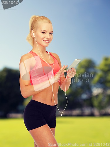 Image of smiling sporty woman with smartphone and earphones