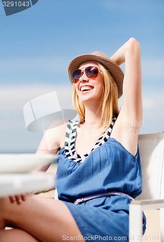 Image of girl in shades in cafe on the beach