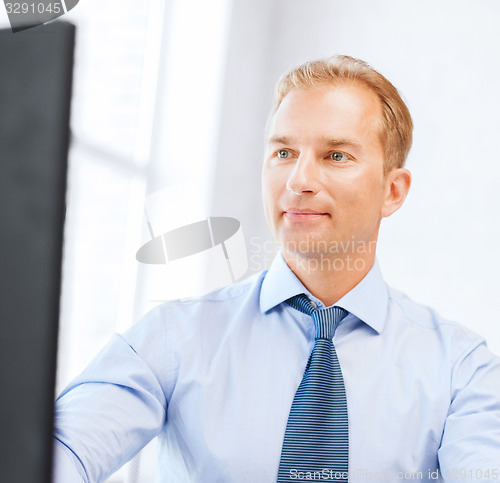 Image of businessman with calculator, computer and papers