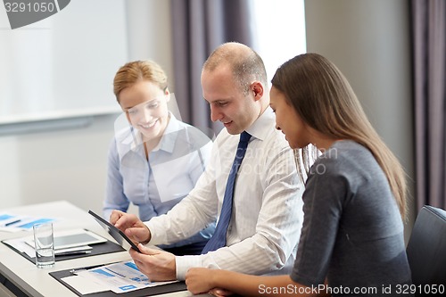 Image of smiling business people with tablet pc in office