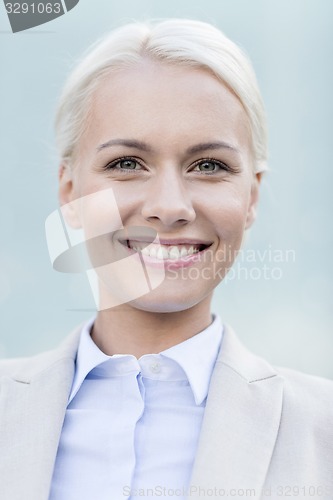 Image of young smiling businesswoman over office building