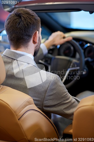 Image of close up of man in cabriolet car at auto show