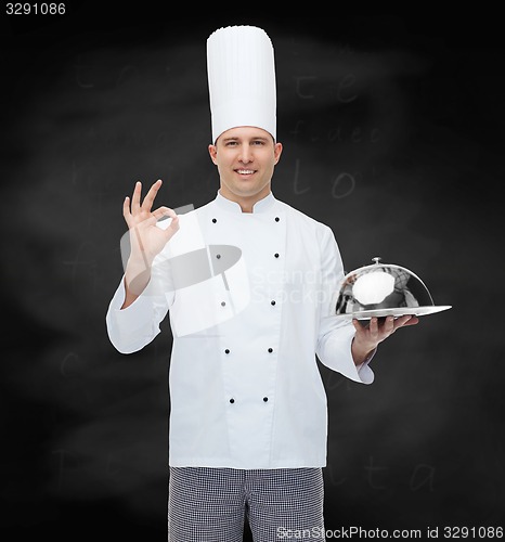 Image of happy male chef cook with cloche showing ok sign