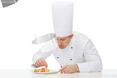 Image of happy male chef cook decorating dish