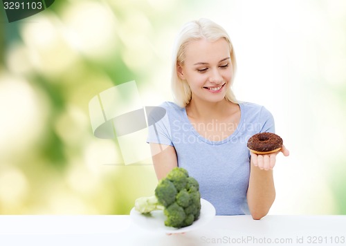 Image of smiling woman with broccoli and donut